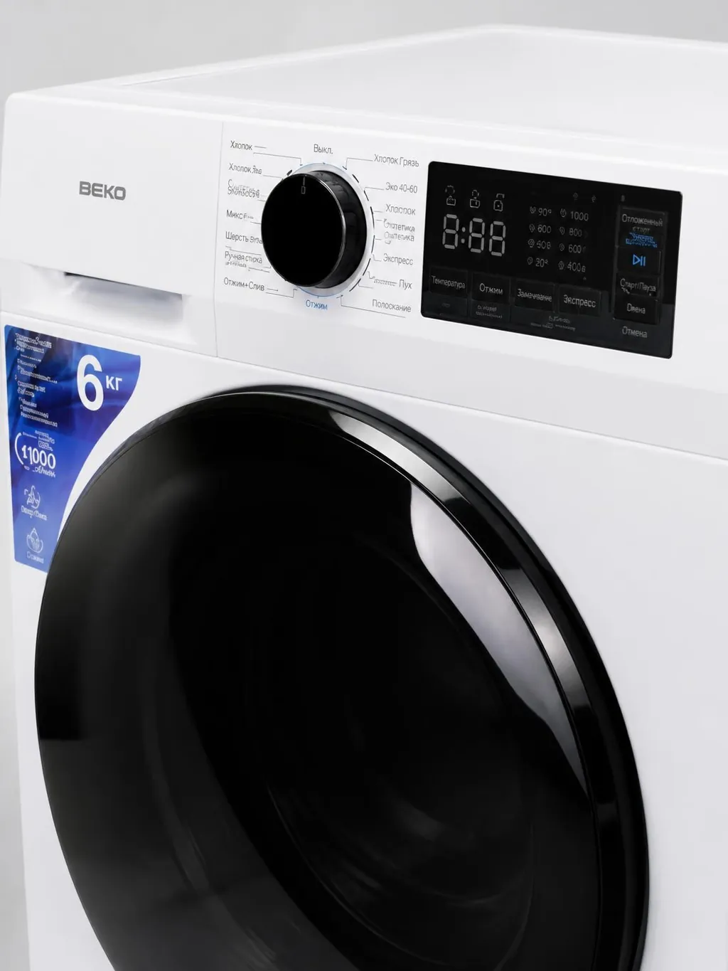 Крупный план панели управления и люка стиральной машины BEKO